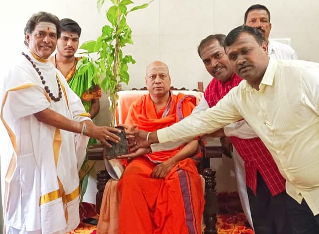 ಚಿತ್ರ ಏಕ್ ಲಾಖ್ ಪೇಡ್ ಮಾ ಕೇ ನಾಮ್ ಅಭಿಯಾನ ನಿಮಿತ್ತ ಕೇಂದ್ರ ಸರ್ಕಾರದ ರಾಜ್ಯ ಅಭಿವೃದ್ಧಿ, ಸಮನ್ವಯ ಹಾಗೂ ಮೇಲುಸ್ತುವಾರಿ ಸಮಿತಿ ಸದಸ್ಯ ಶಿವಯ್ಯ ಸ್ವಾಮಿ ಅವರು ಶ್ರೀಶೈಲದಲ್ಲಿ ಜಗದ್ಗುರು ಡಾ. ಚನ್ನಸಿದ್ಧರಾಮ ಪಂಡಿತಾರಾಧ್ಯ ಶಿವಾಚಾರ್ಯರಿಗೆ ಬಿಲ್ವಪತ್ರಿ ಸಸಿ ವಿತರಿಸಿದರು